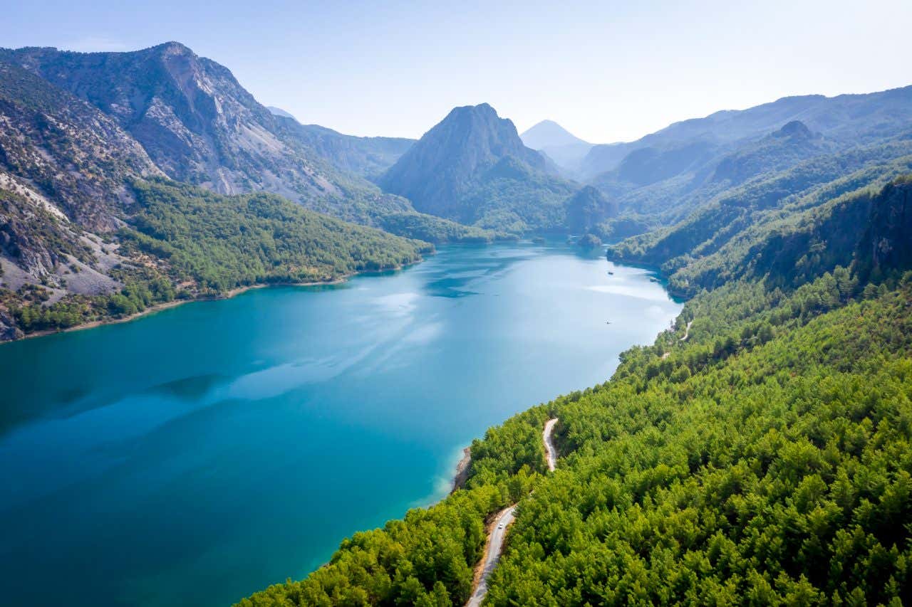 Montagnes couvertes de végétation e entourant un lac d'un bleu intense par temps ensoleillé