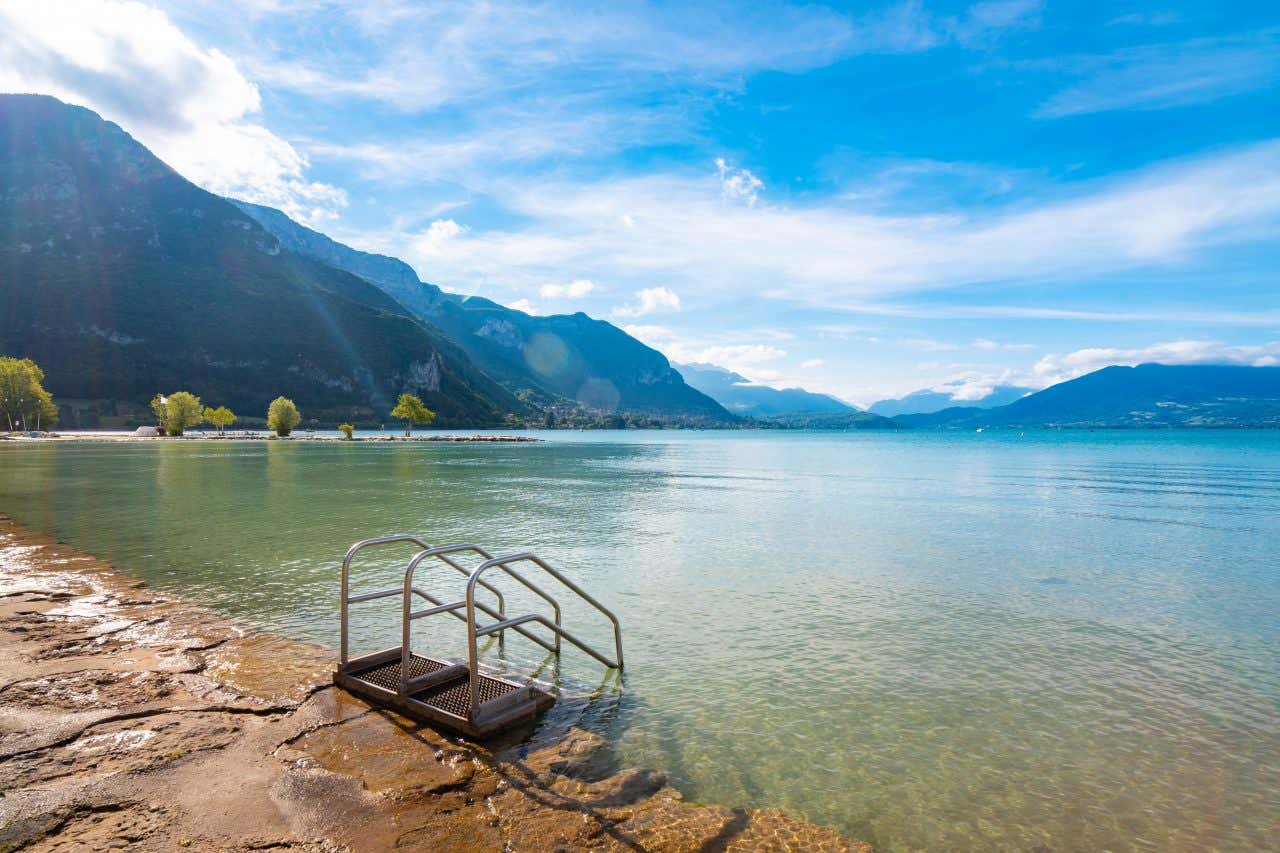 Escalier qui descend dans le lac au bord d'une plage tranquille du lac d'Annecy