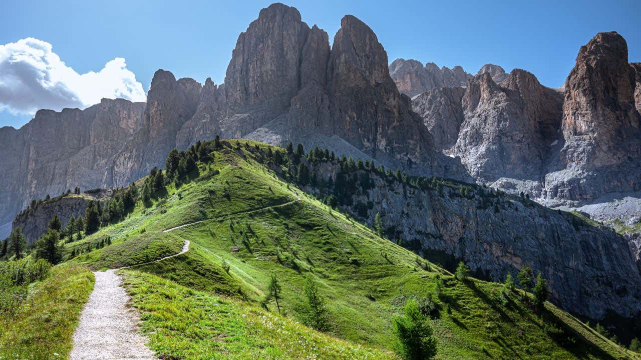 A path in the Dolomites with a rocky mountainous landscape in the background.