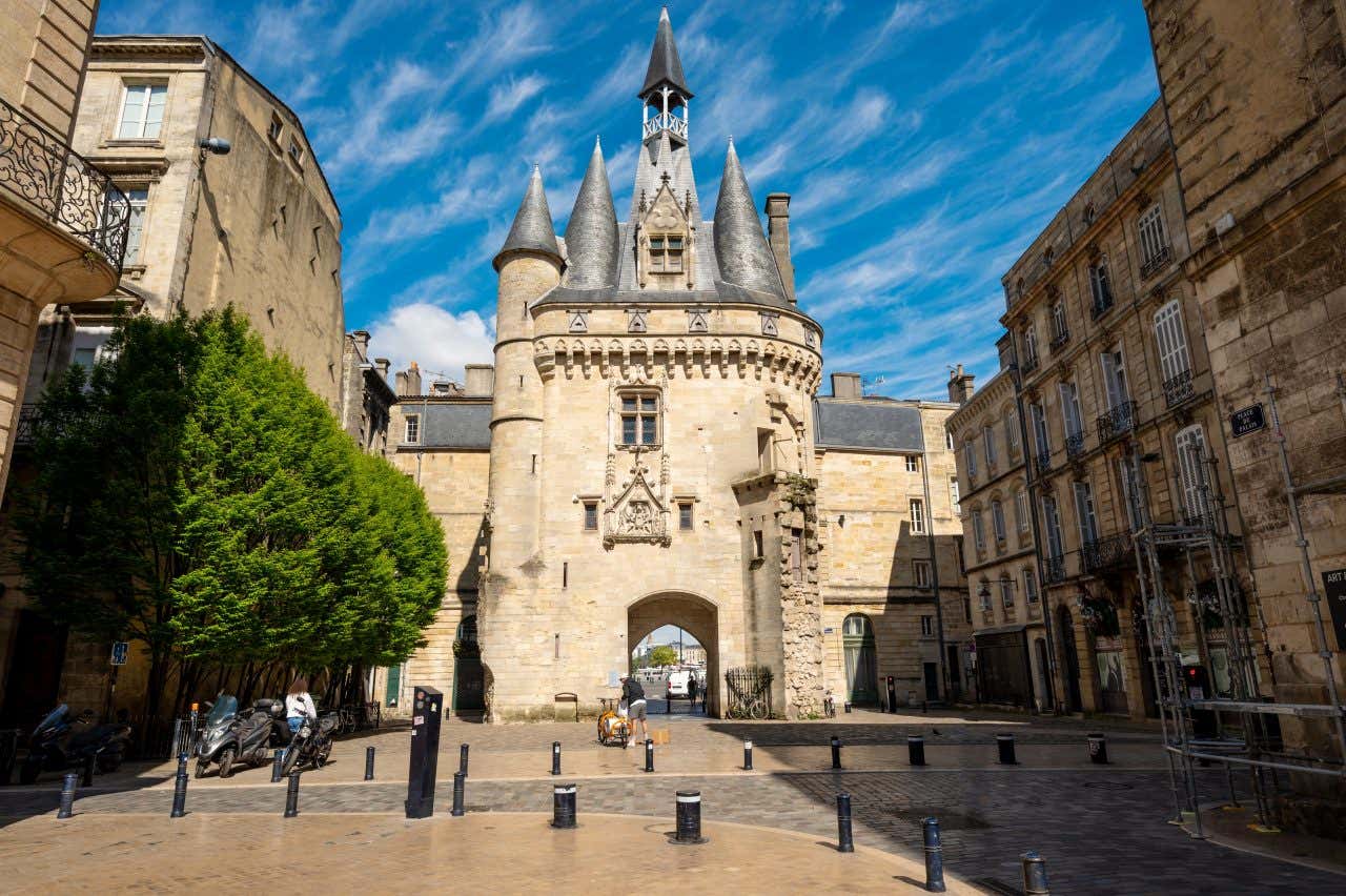 Porte Cailhau au détour d'une ruelle vide sous un ciel bleu, une visite à faire à Bordeaux pendant votre week-end