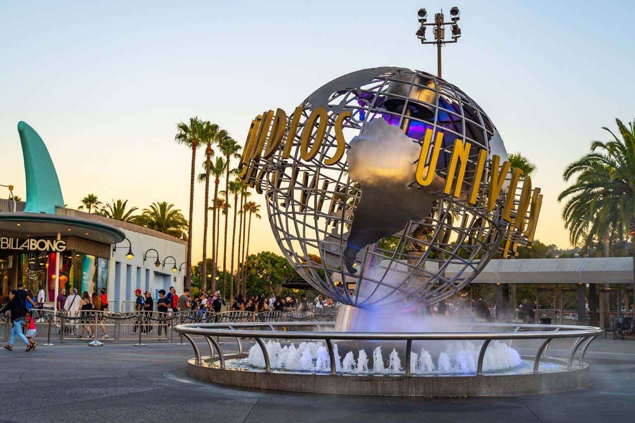 Universal Studios Hollywood sign at sunset with a yellow and blue sky.