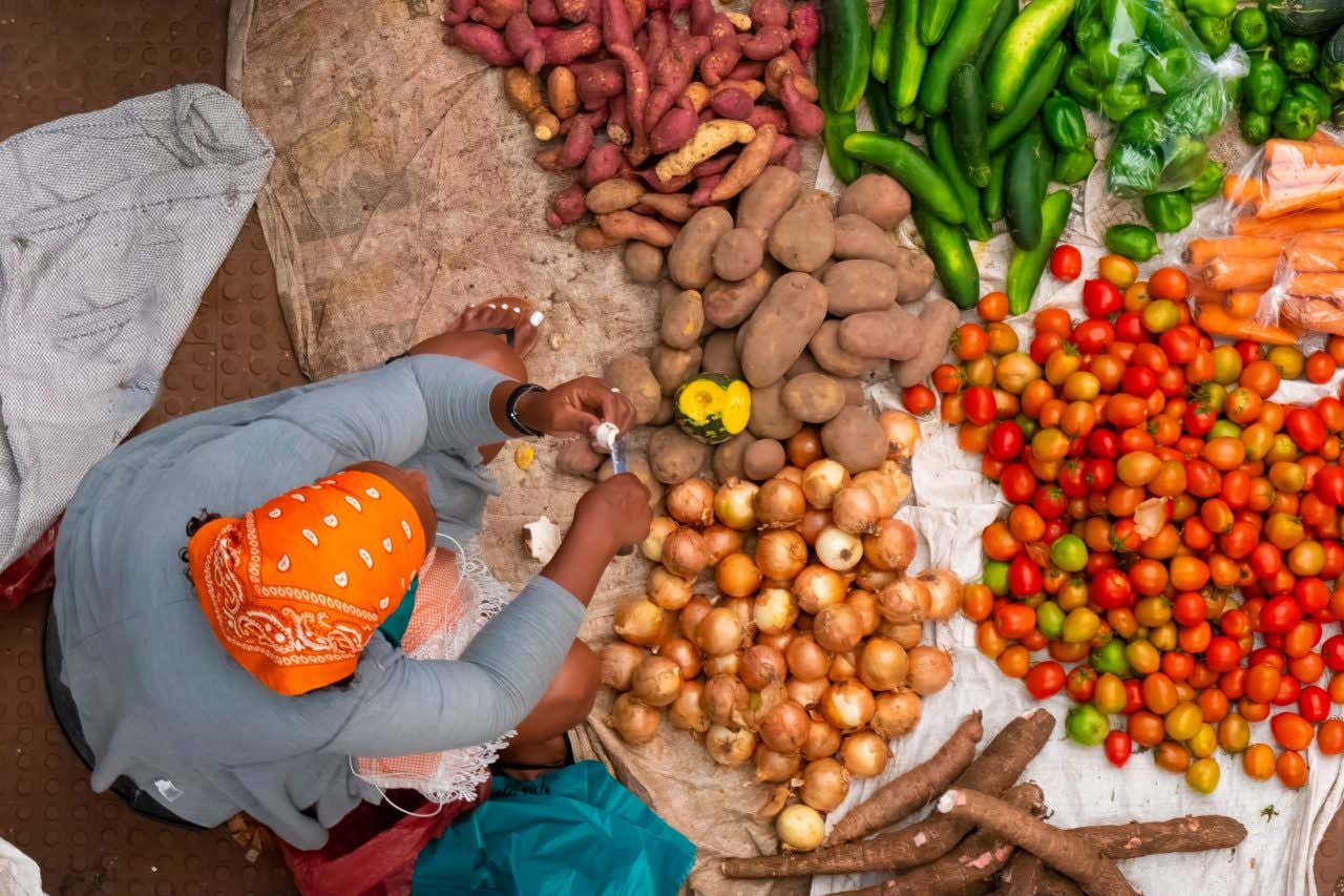 Vue en plongée d'une femme vendant des légumes à São Vicente
