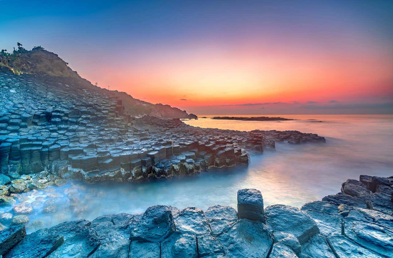 Vue sur les formatons rocheuses de la Chaussée des Géants à la tombée de la nuit, une visite à faire absolument en Irlande