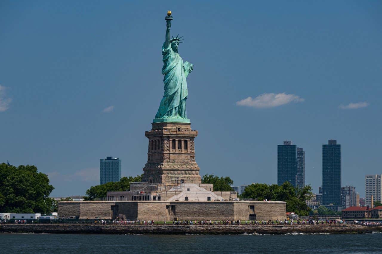 A shot of the Statue of Liberty with the NYC skyline in the background.