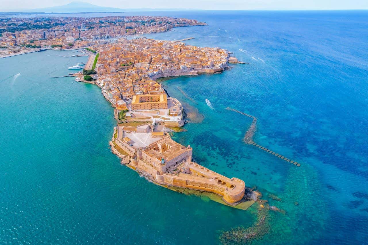 Vue aérienne sur Syracuse en arrière-plan et sur Ortygie, entourée des eaux turquoises de la Méditerranée