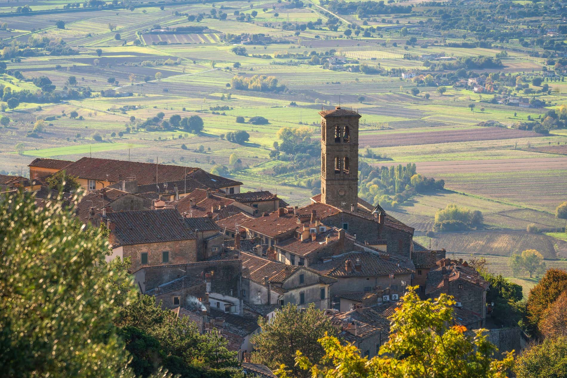 Panoramica di un borgo toscano sulla collina con un campanile che svetta fra le case