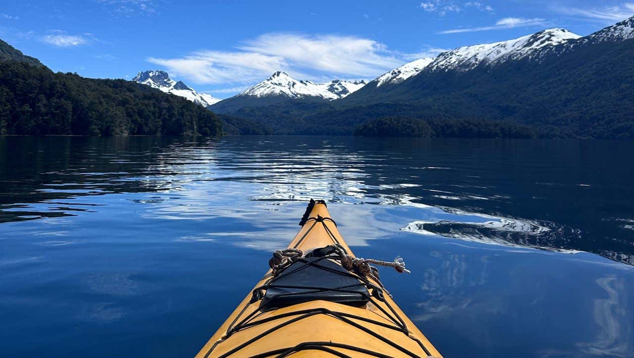 Kayak sur un lac de Patagonie avec des montagnes eneigées en arrière-plan