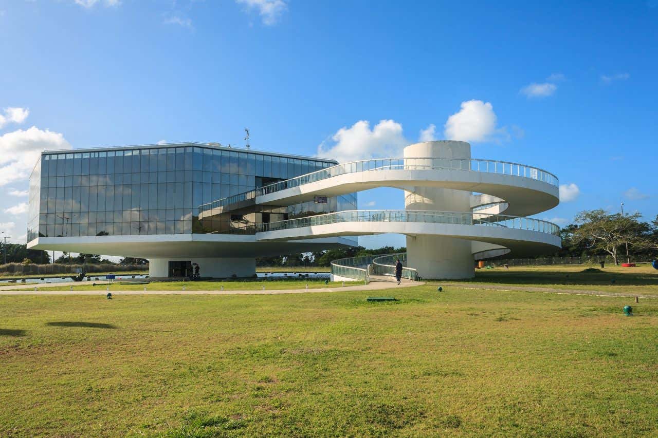 Um edifício futurista com rampas em espiral em um campo gramado