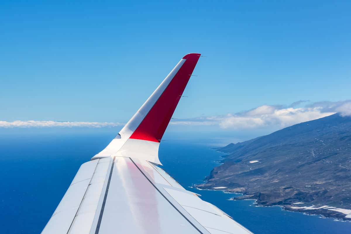 Alas de un avión sobrevolando una isla