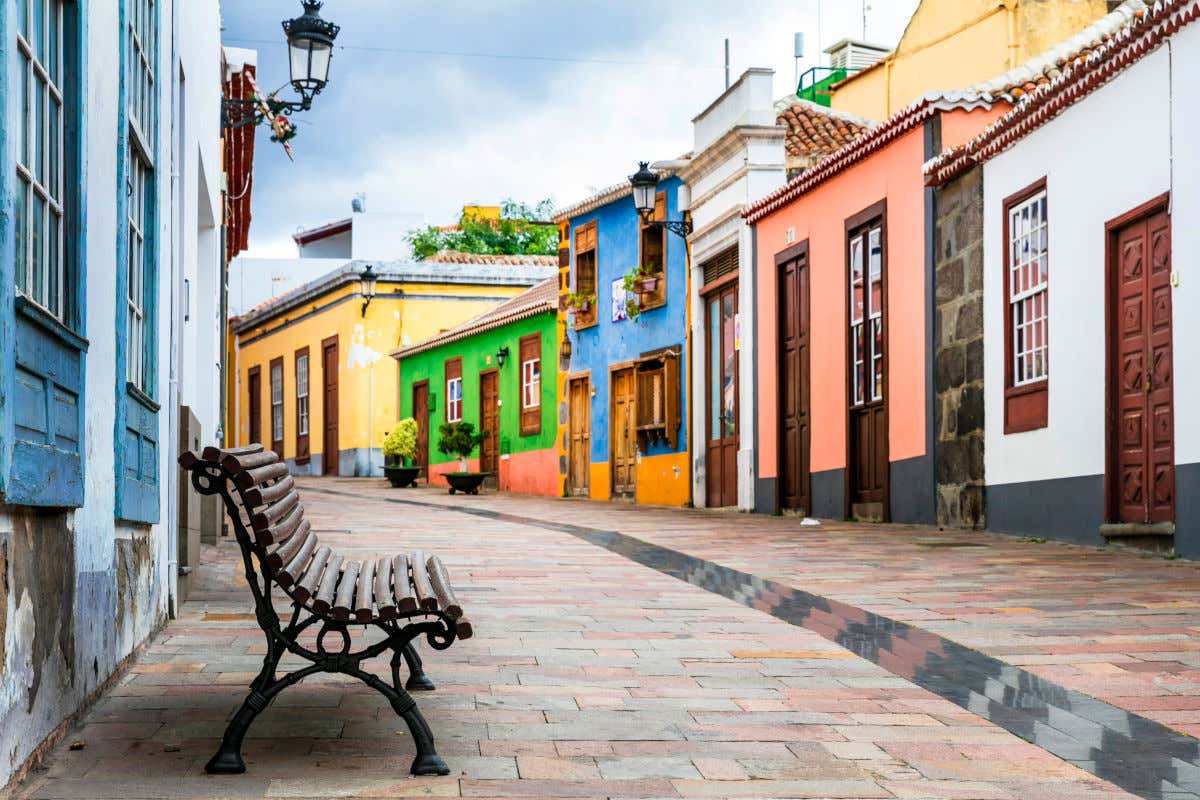 Una calle peatonal sin gente y con varias casas coloniales de vivos colores y con puertas y ventanas de madera