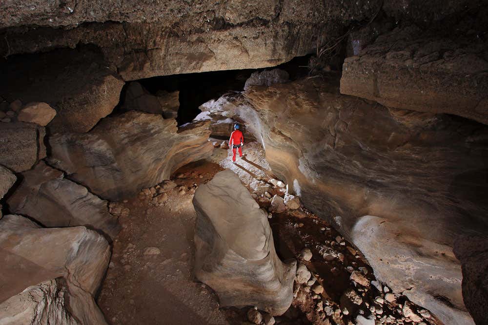 Una persona haciendo espeleología en una cueva