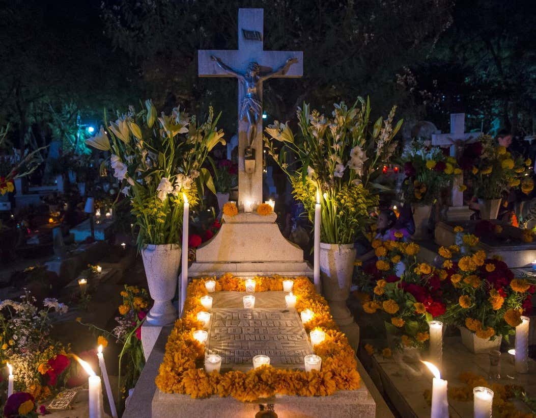 Tumbas adornadas con flores y velas durante el Día de Muertos en Oaxaca