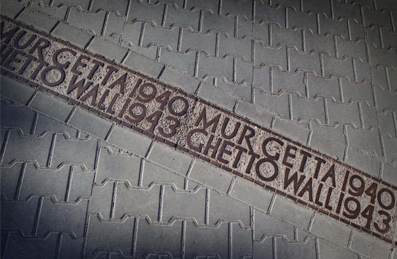 Un solco di cemento nel manto stradale del centro di Varsavia che segnala, con delle scritte in polacco e inglese, che lì è dove passata il muro perimetrale costruito dai nazisti per ghettizzare gli ebrei tra il 1940 e il 1943
