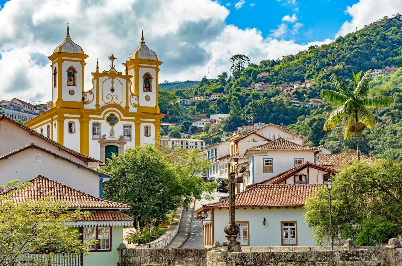 Panorâmica de Ouro Preto, com uma igreja e construções coloniais com vegetação ao fundo