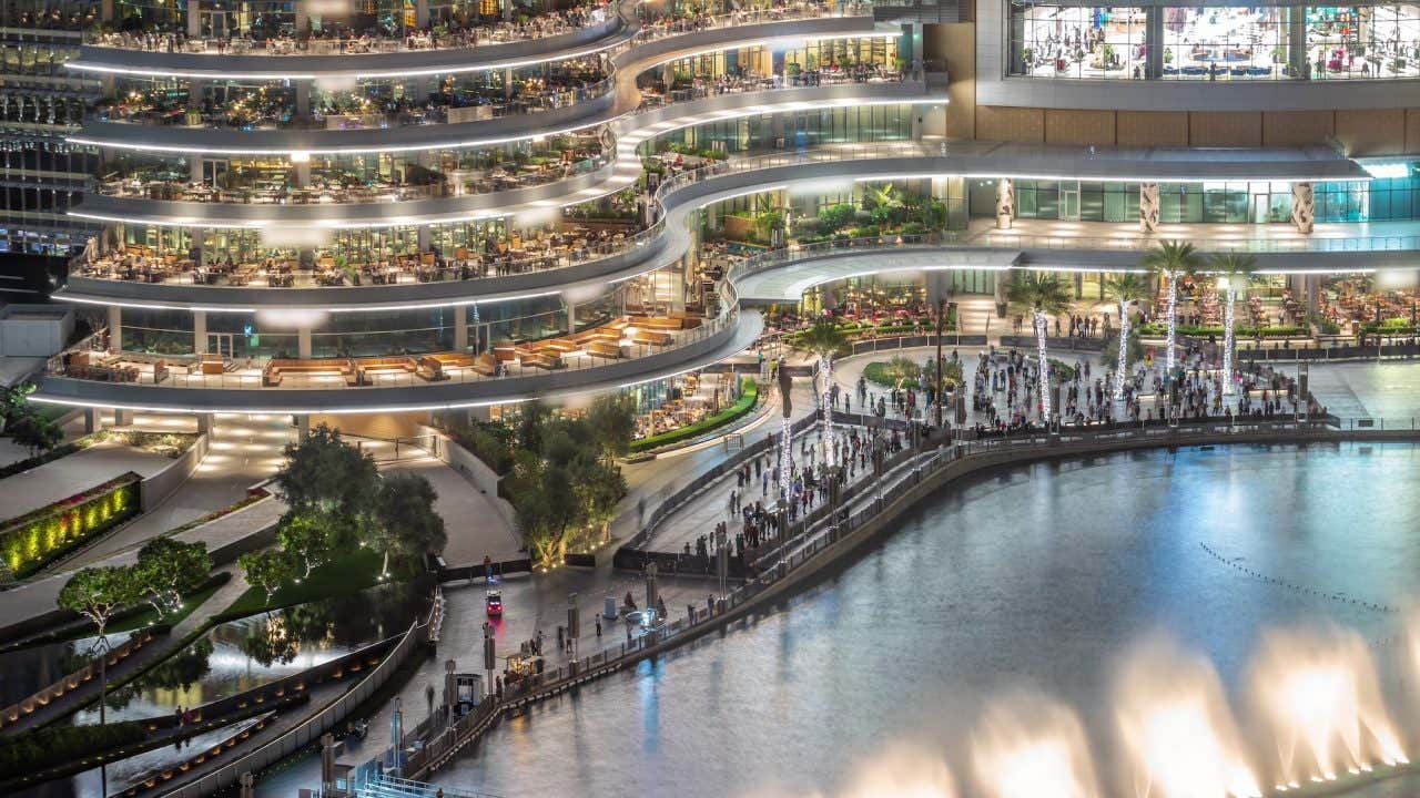 Varanda de shopping center com restaurantes perto da fonte no centro de Dubai