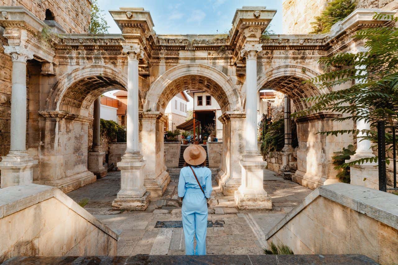 Femme devant la Porte d'Hadrien à Antalya, une visite à faire lors de votre séjour