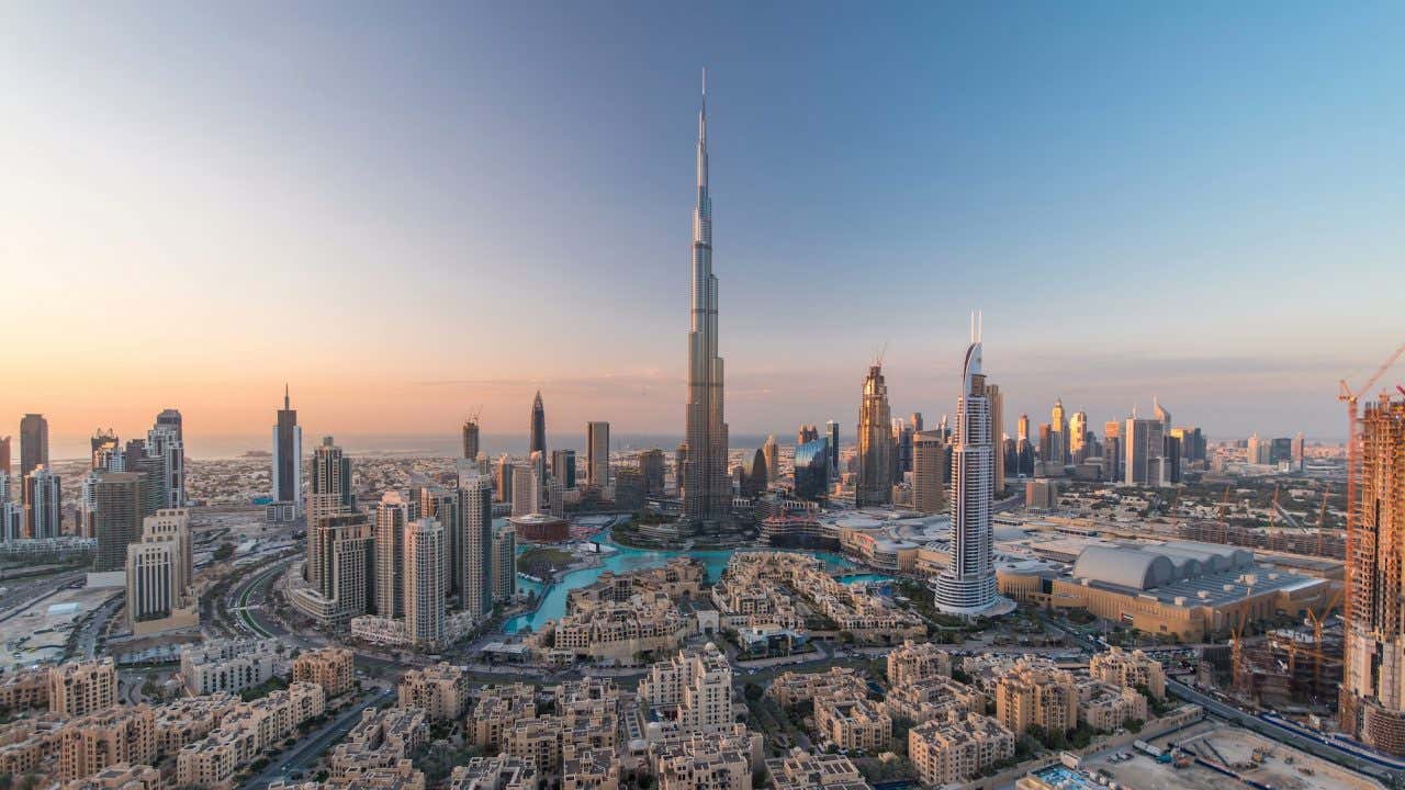 Edifícios de Dubai com o Burj Khalifa ao centro ao entardecer