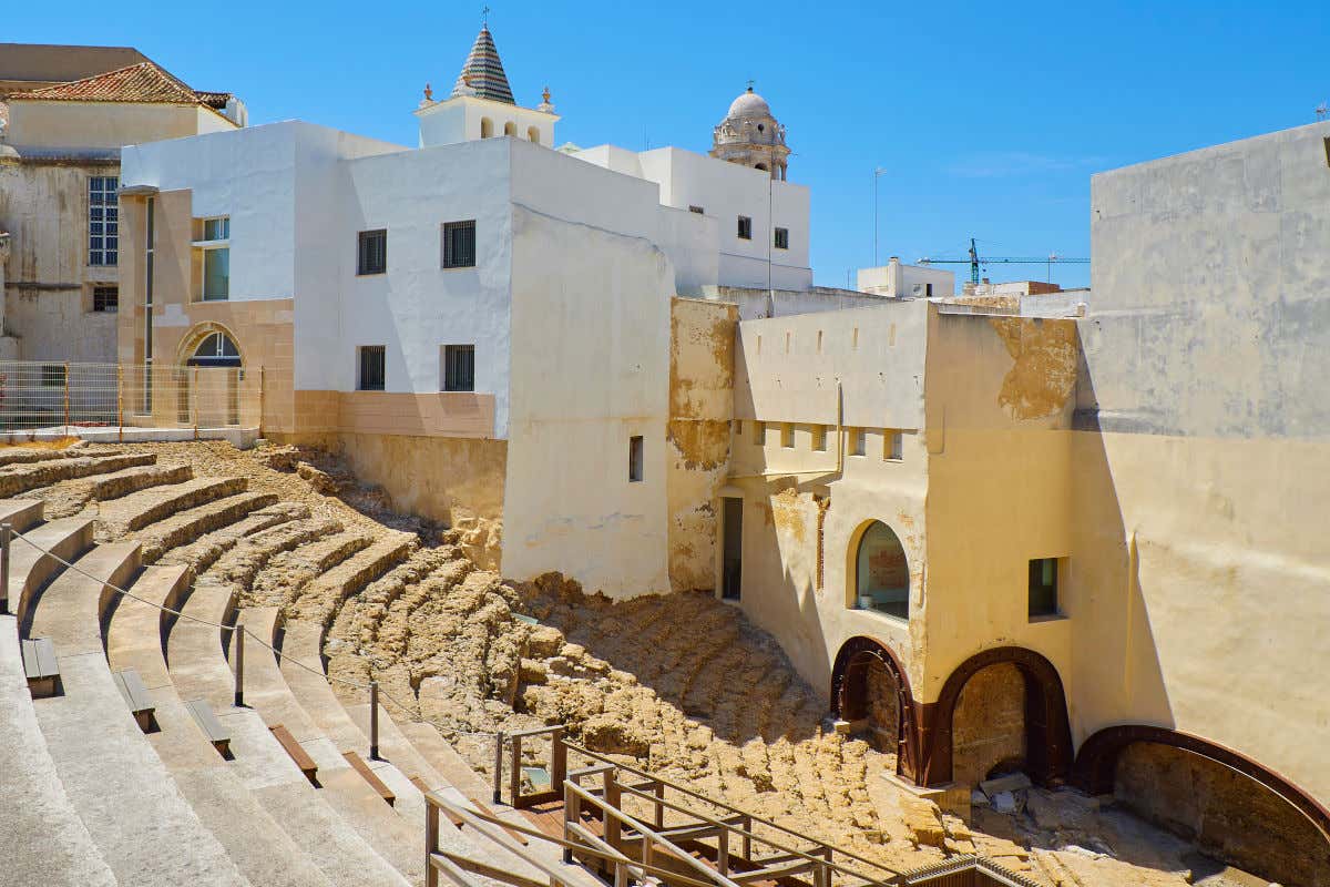 Graderío en ruinas del antiguo teatro romano de Cádiz, enmarcado en mitad de varias casas