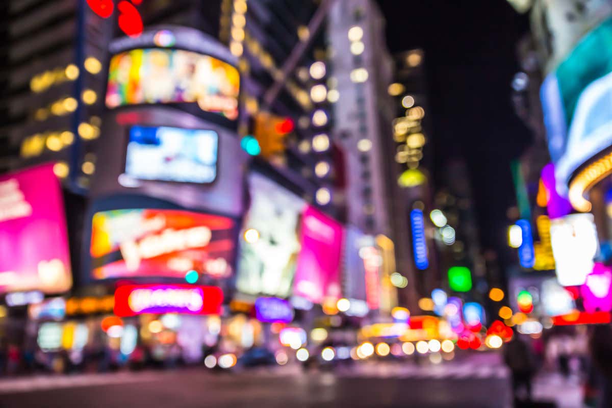 Visión borrosa o desenfocada de los carteles iluminados de Times Square por la noche