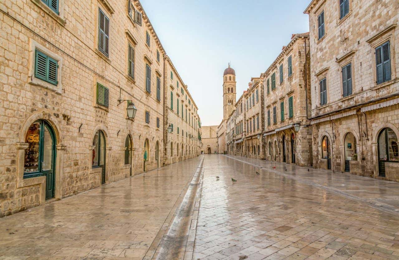 Una calle pavimentada en piedra caliza rodeada de edificios históricos
