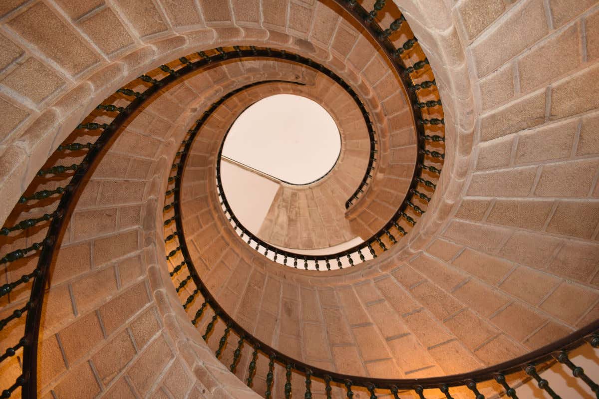 Unas escaleras de piedra que van girando a modo de torre en el interior de un edificio