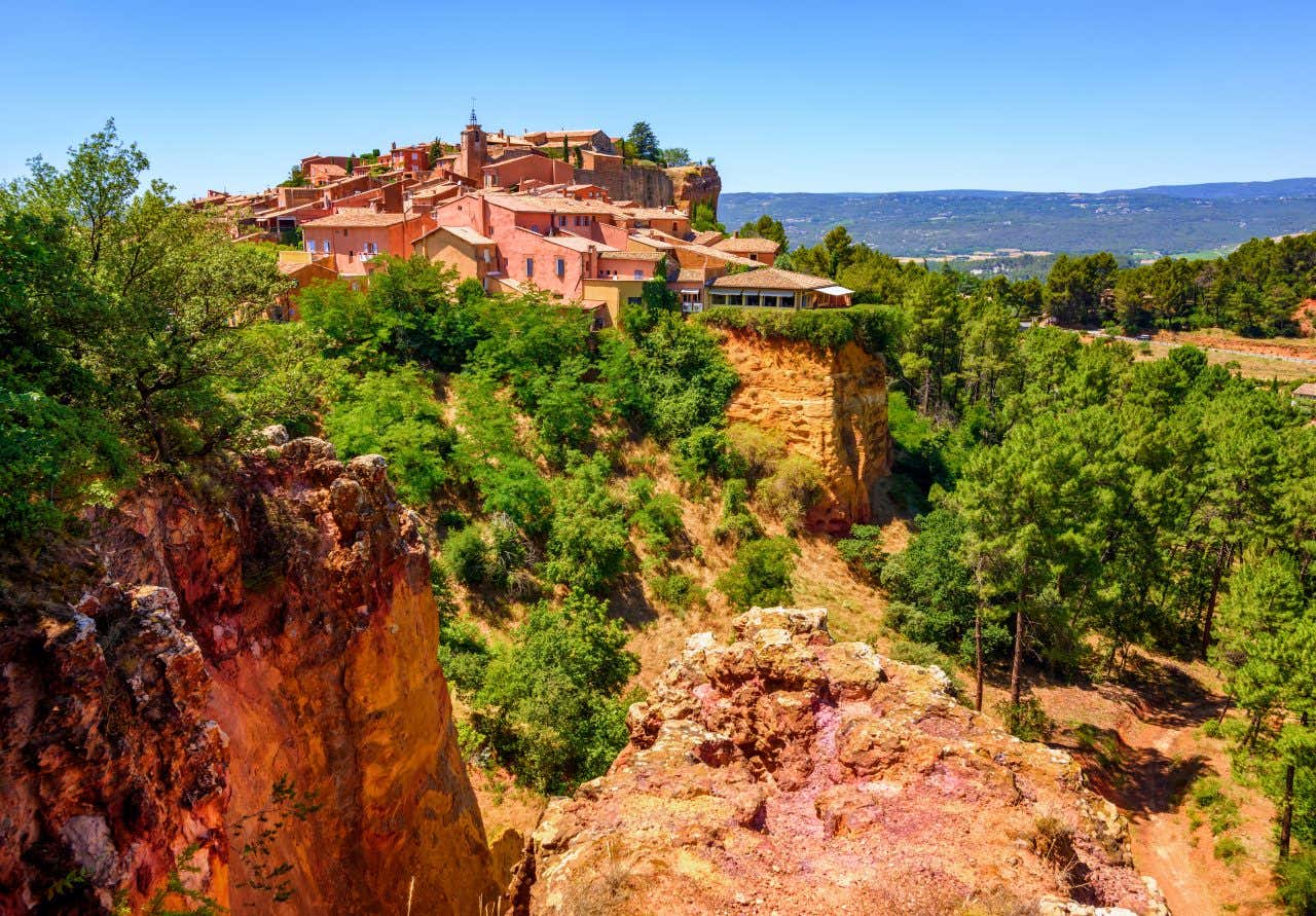 Vue sur le village de Roussillon en arrière-plan et les carrières d'ocre en premier plan