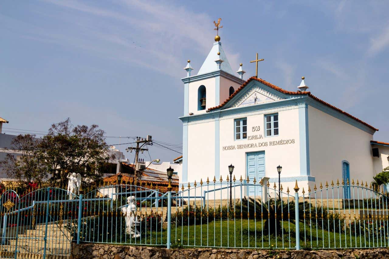Fachada simples branca e azul da igreja de Nossa Senhora dos Remédios em Arraial do Cabo