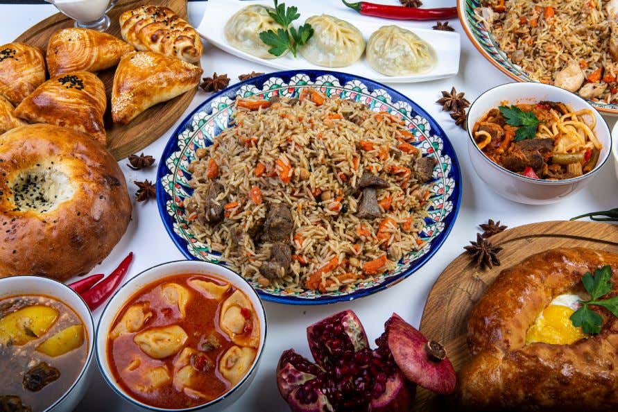 A view of several dishes of Uzbek food on a table.