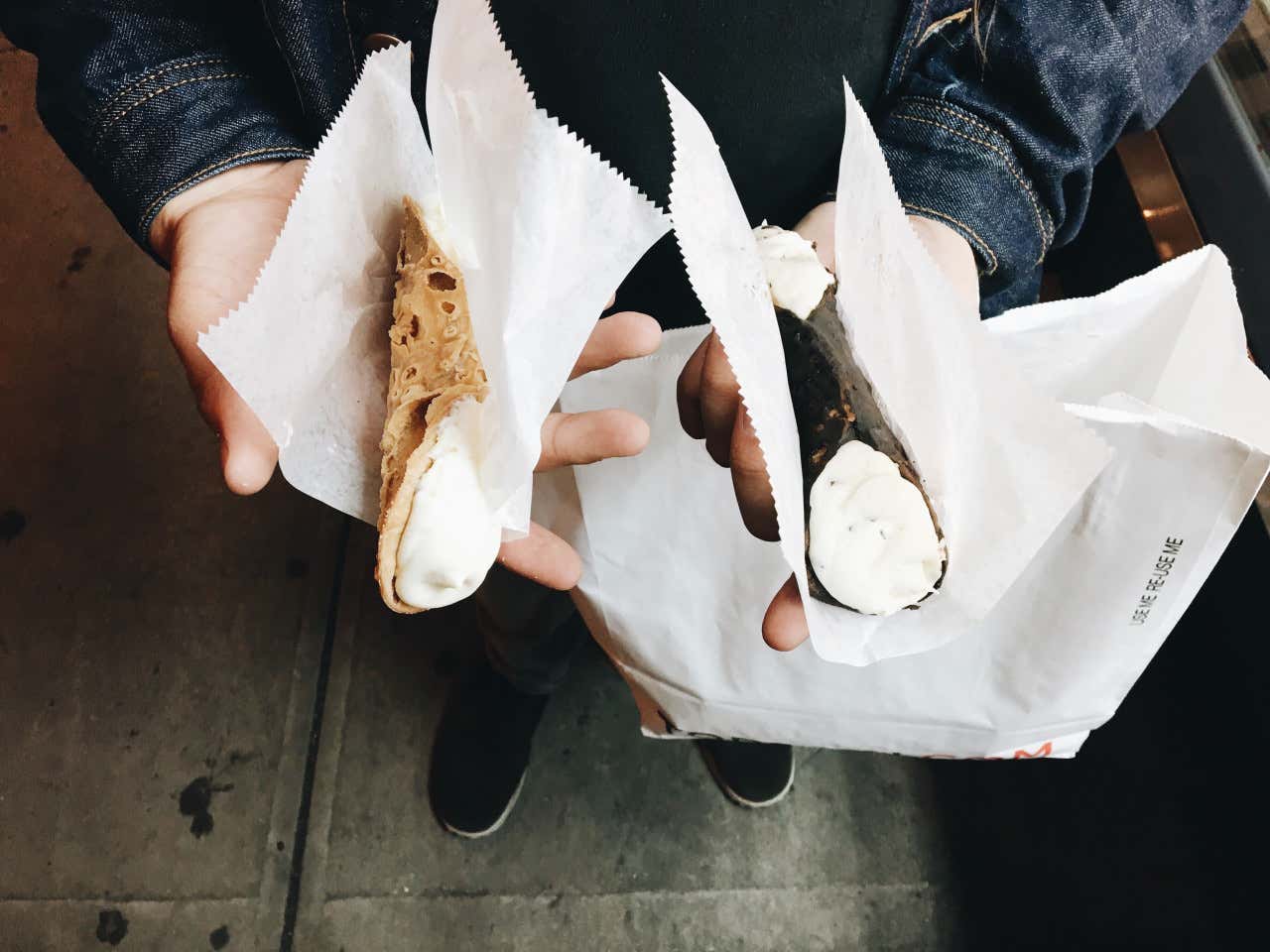 Dos manos sujetando dos cannoli típicos italianos