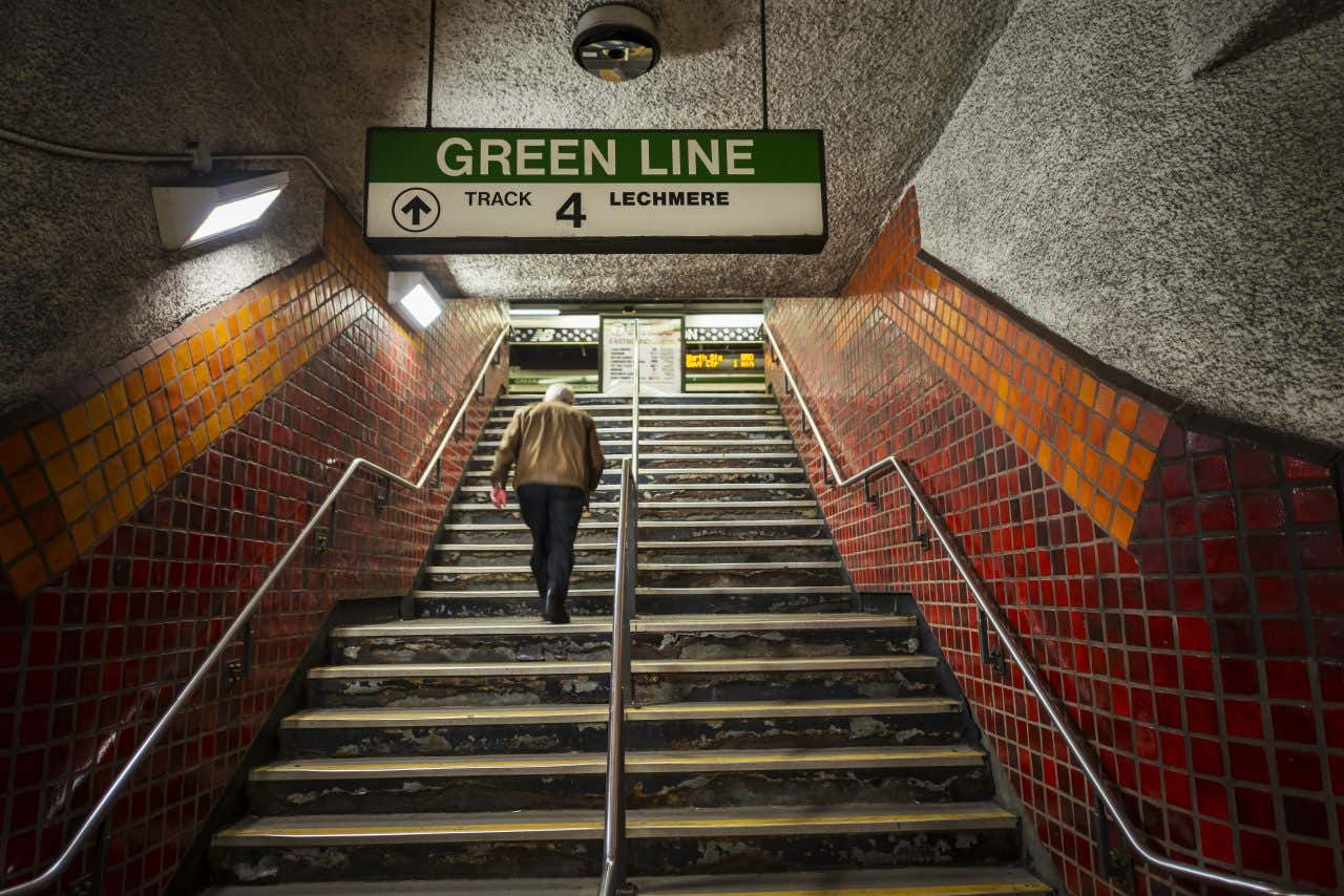 Insegna della stazione metro di Chamberí, la fermata fantasma della metropolitana di Madrid. Il cartello è blu con lettere bianche e incorniciato da una forma romboidale rossa su sfondo di piastrelle bianche e dettagli decorativi in ceramica verde e marrone ai lati