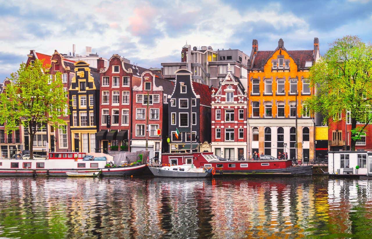 Canal d'Amsterdam, avec des maisons colorées devant des bateaux sur le cours d'eau