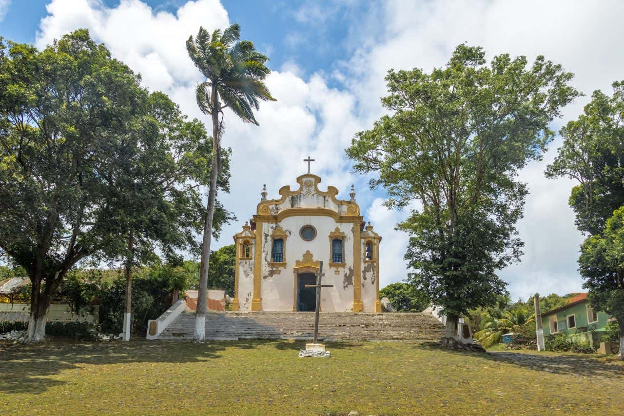 Fachada colonial da igreja de Nossa Senhora dos Remédios rodeada de árvores