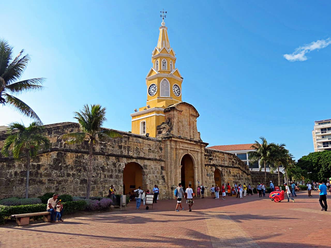 Personas paseando por la Torre del Reloj de Cartagena, entrada a las murallas