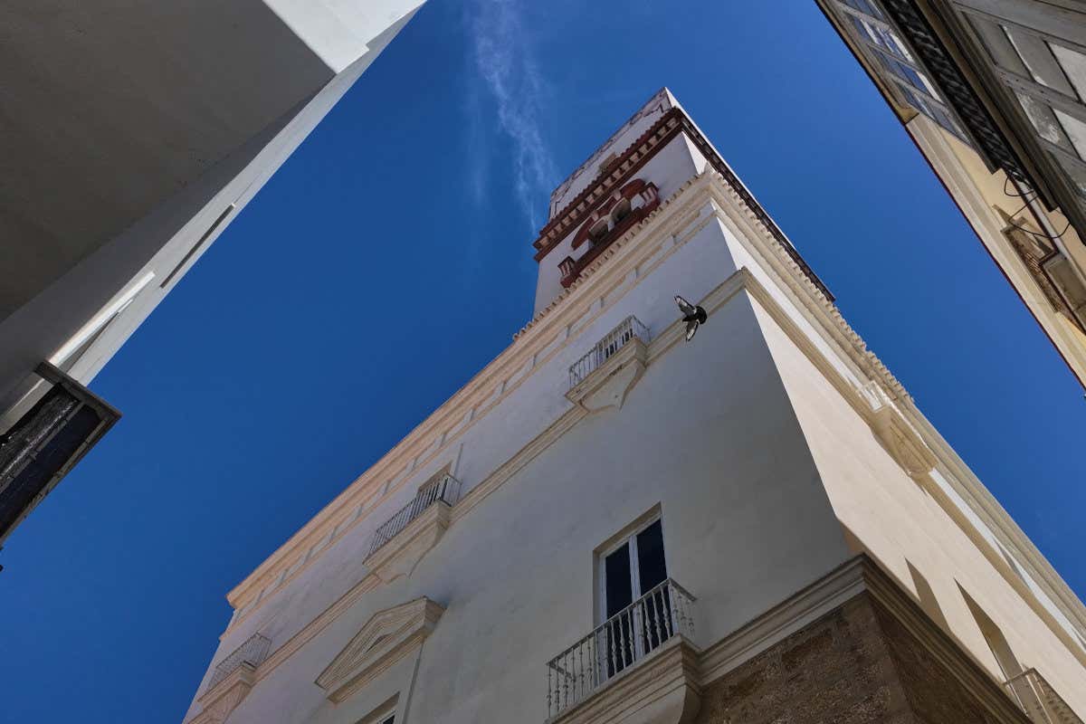 Vista desde el suelo de una torre con decoración rojiza en mitad de una ciudad