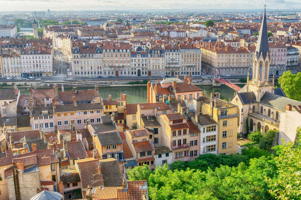Una iglesia y varias casas se extienden junto a las orillas de un río en la ciudad de Lyon