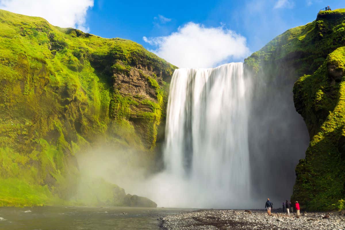 Una cascada de gran altura cutas aguas fluyen a través de una montaña cubierta de un manto verde