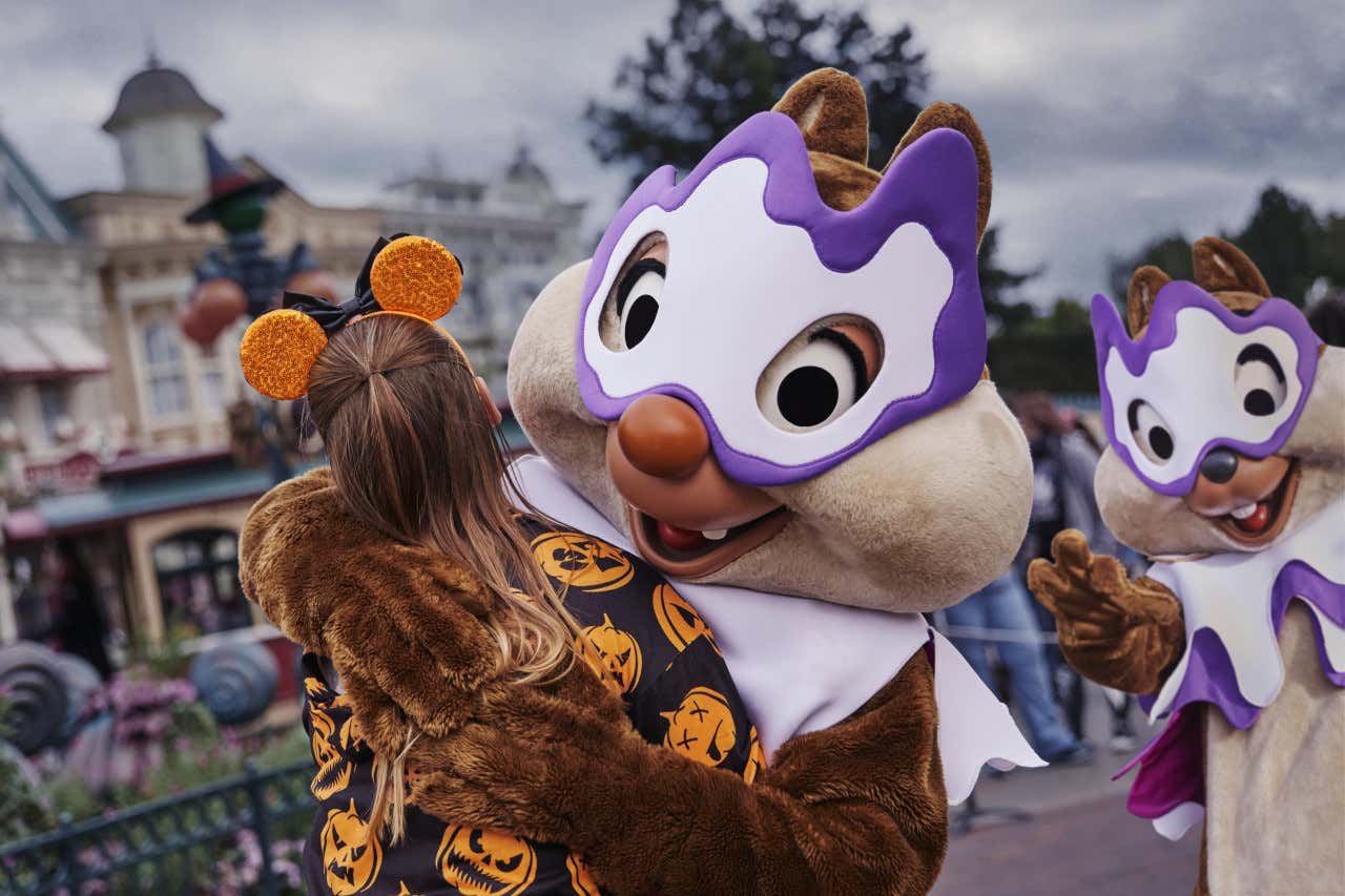 Uma menina de costas abraçando Tico e Teco, personagens da Disney