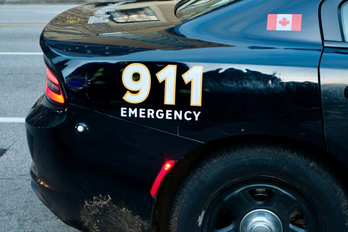 Detalle de un coche de color negro con el número 911 Emergy y la bandera de Canadá