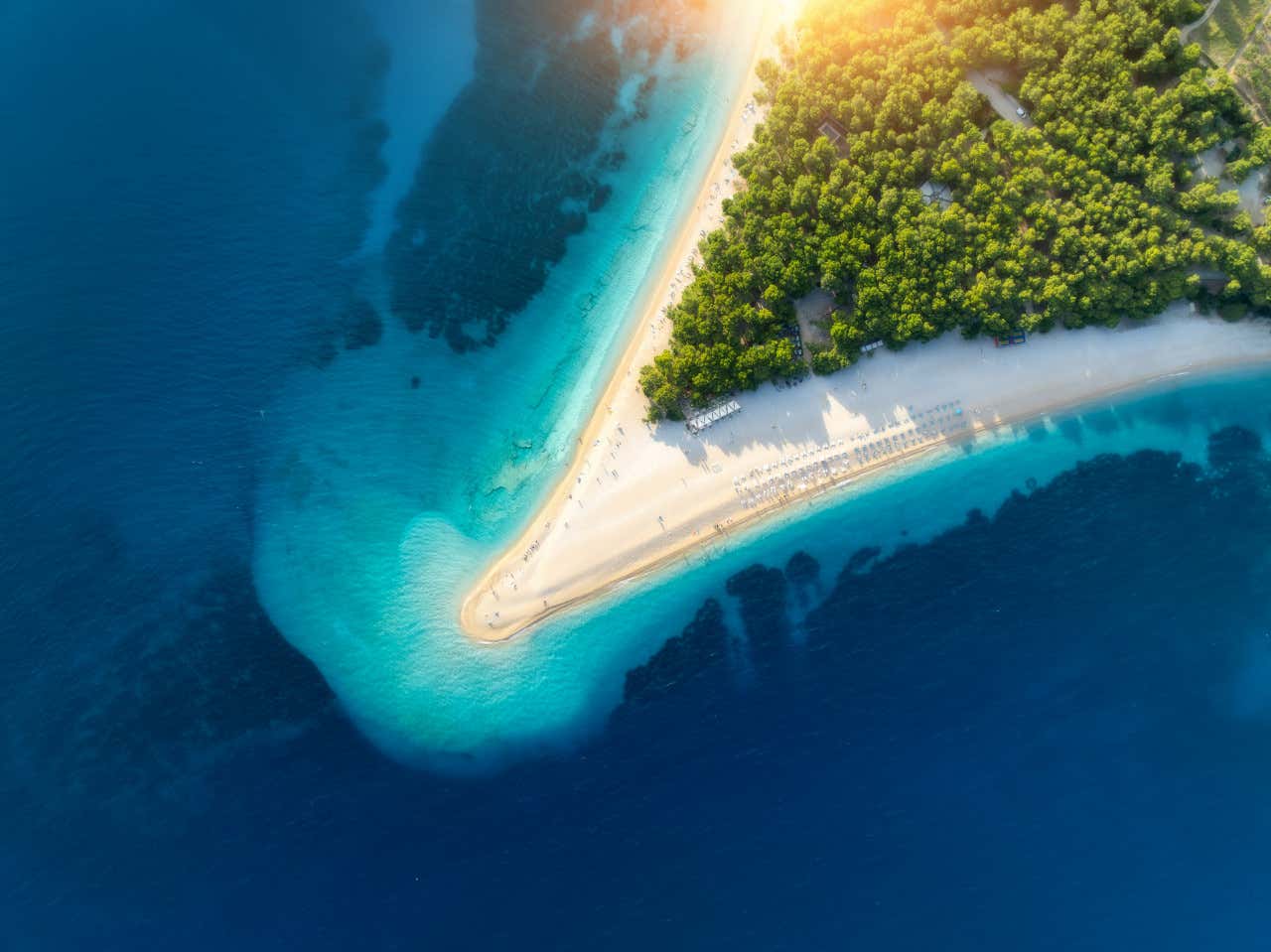 Vista aérea de la playa "cuerno del oro" en la isla de Brac, Croacia, rodeada de una exuberante vegetación y un mar azul profundo