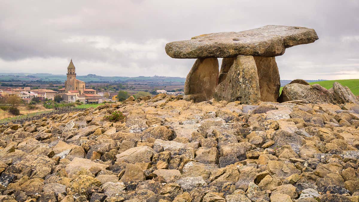 Vista panorámica del Dolmen de La Hechicera con las vistas de un pueblo de fondo