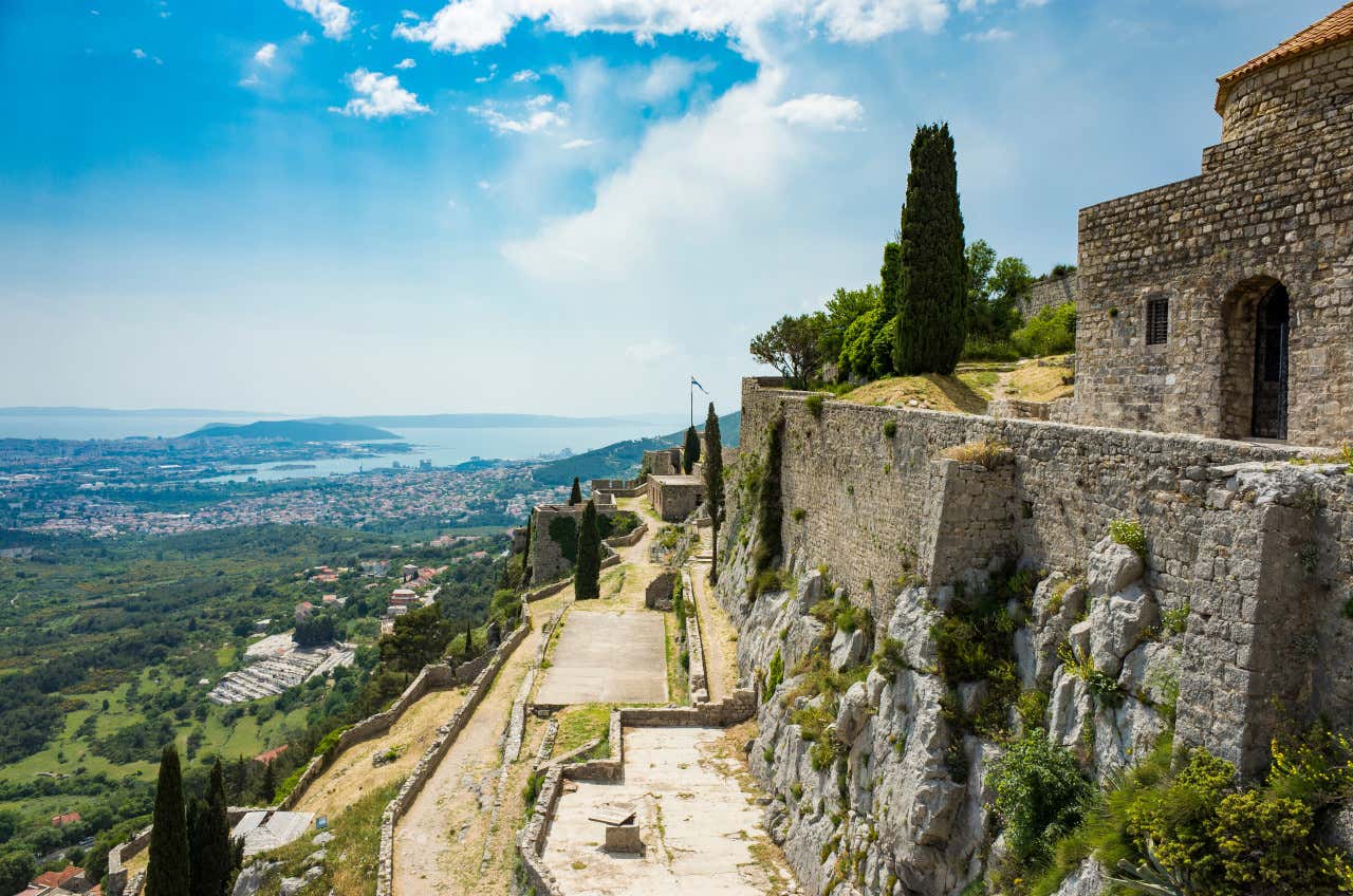 Ruinas de la Fortaleza de Klis y edificios antiguos en la cima de alta montaña sobre el mar Adriático