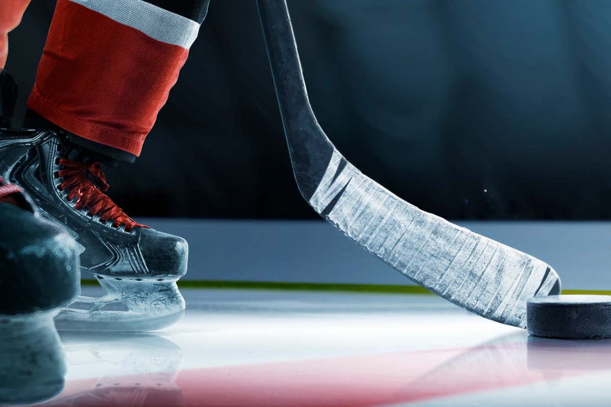 Detalle de una pista de un pabellón deportivo, en la que se ve a una persona practicando hockey sobre hielo