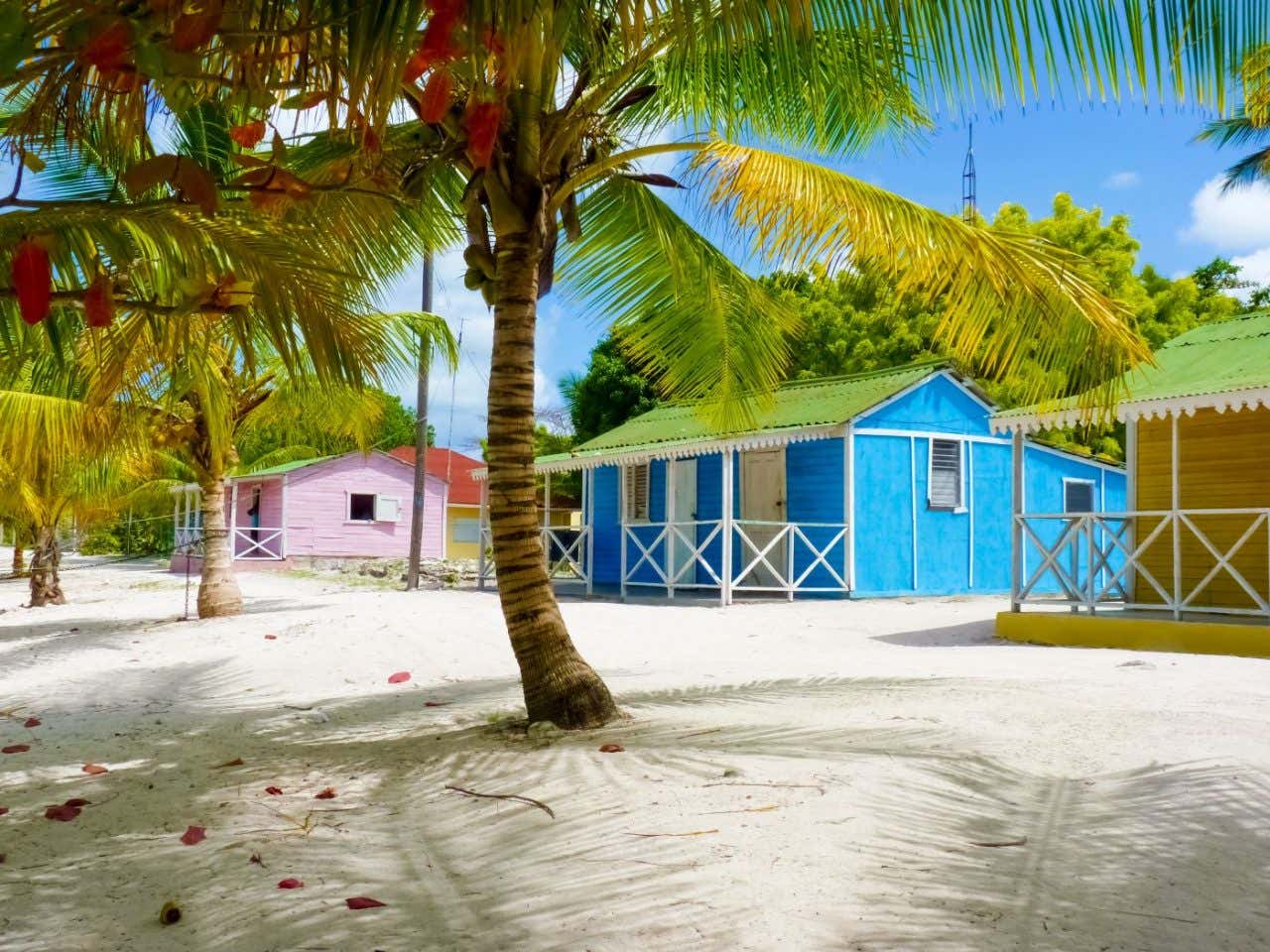 Unas casas de colores en una playa de arena blanca
