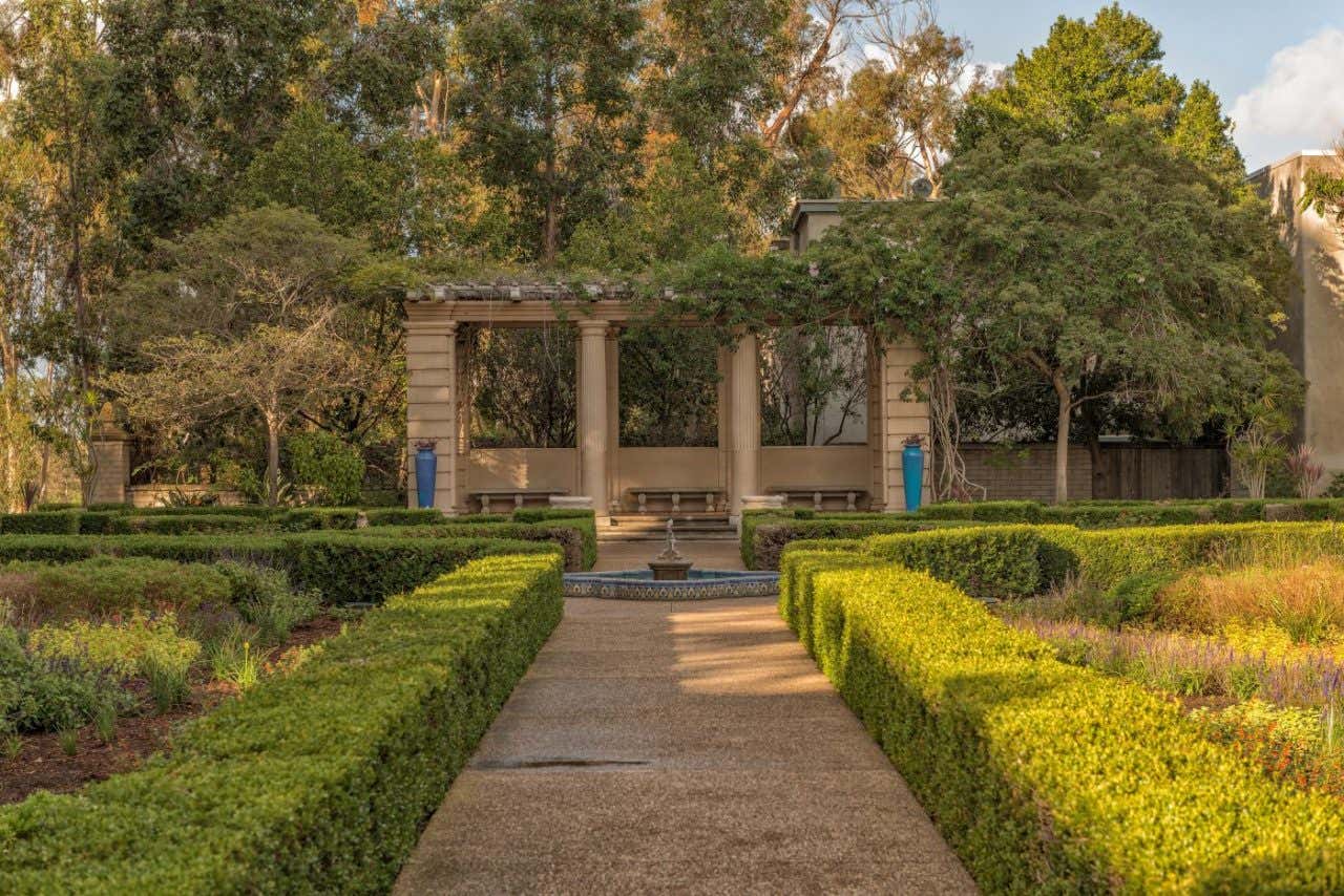 Jardín Alcázar en el Parque Balboa donde se aprecian senderos con densa vegetación