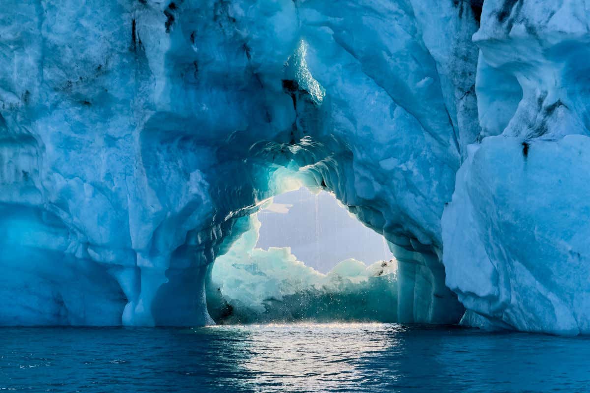Aguas cristalinas de un lago glaciar con enormes bloques de hielo formando arcos de forma natural