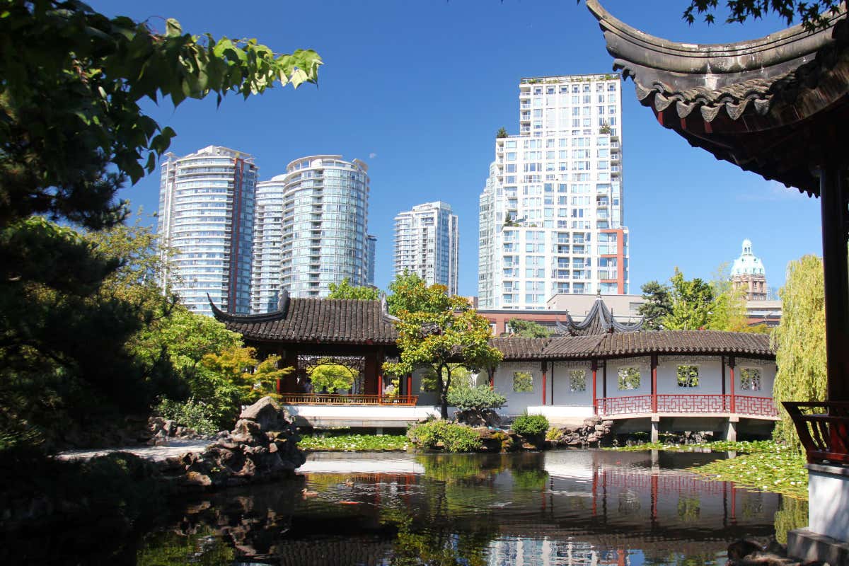 Templos de inspiración oriental junto a un lago, con unos rascacielos de fondo