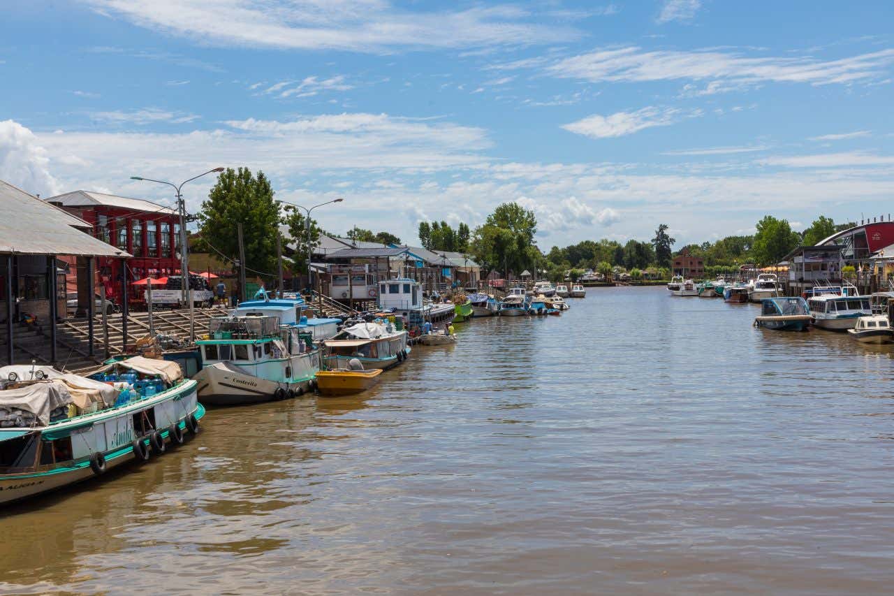 The river coming into the town of Tigre, with a cloudy blue sky in the background.