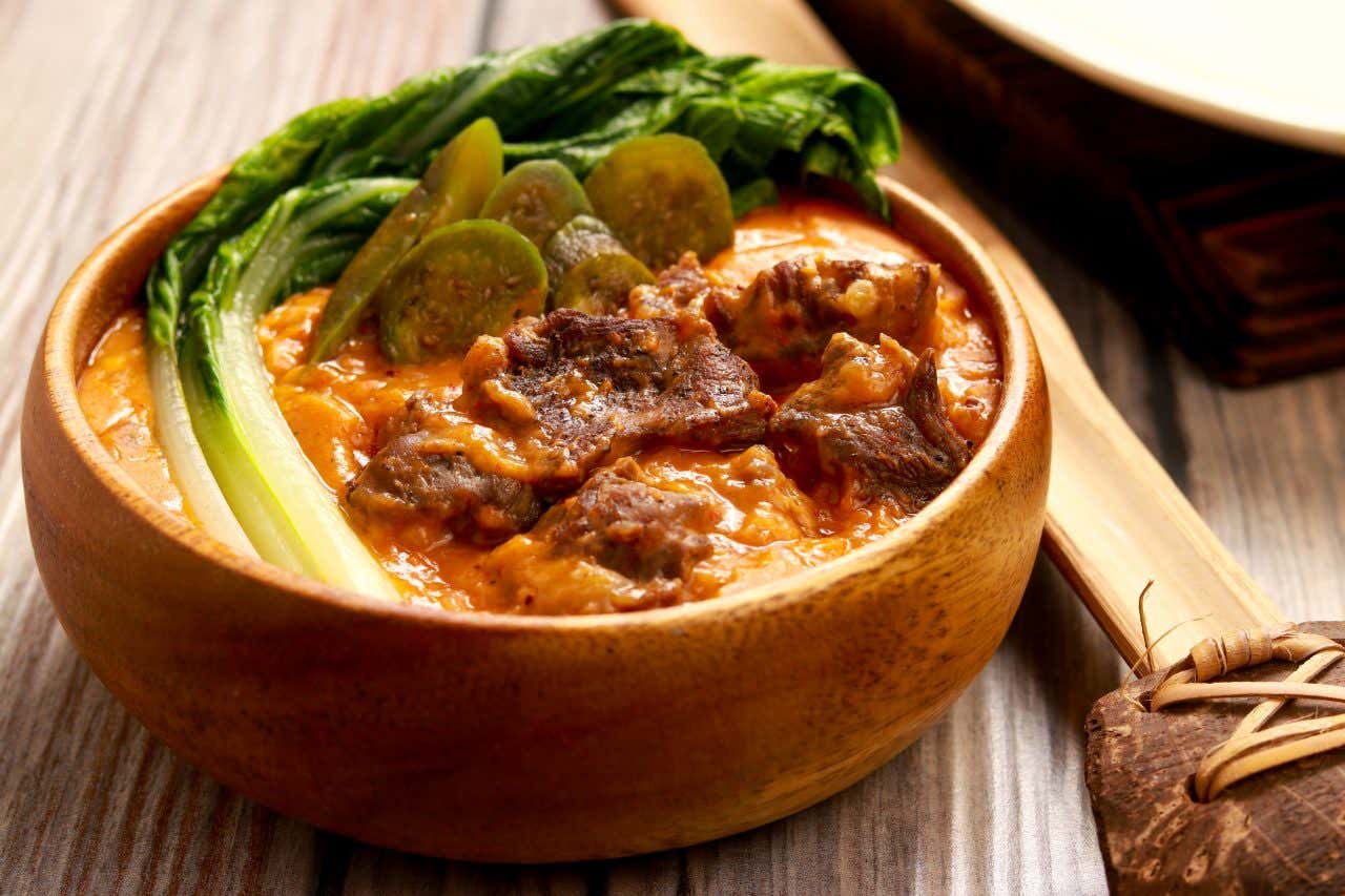 Close up of a bowl of kare-kare, a traditional dish in the Philippines, and in Iloilo City, a secret foodie destination