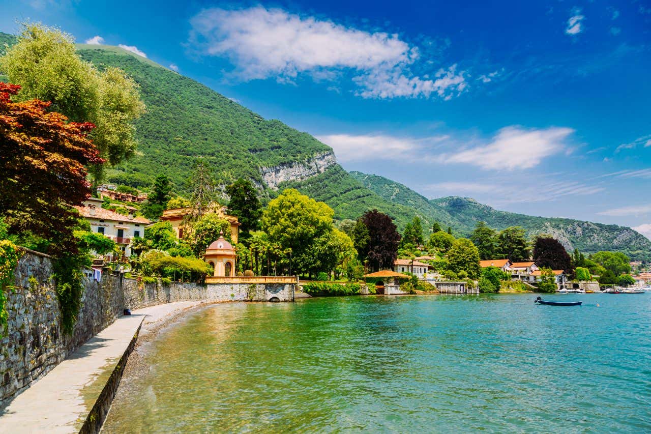 Bord du lac de Côme aux eaux turquoise et village de Lenno avec la montagne verdoyante en arrière-plan