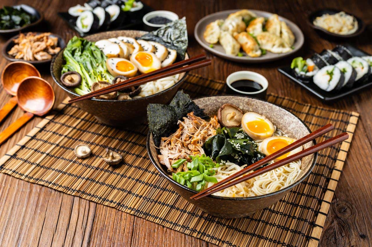 Due ciotole di ramen giapponese con gyoza e futomaki